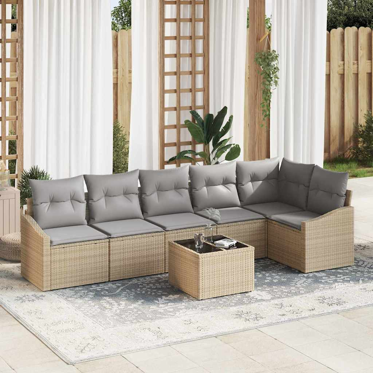 Outdoor-Ecksofa mit grauen Kissen, passendem Couchtisch und Teppich. Weiße Vorhänge und Holzgitter im Hintergrund.