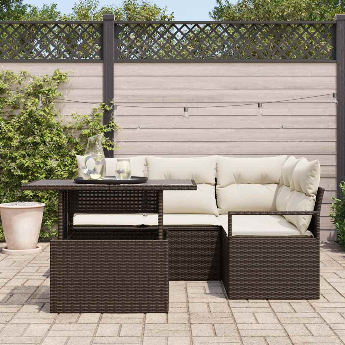 Gartenmöbel-Set. Ein dunkelbrauner gewebter Tisch und ein Sofa mit cremefarbenen Kissen. Der Hintergrund umfasst einen Zaun und Grün.