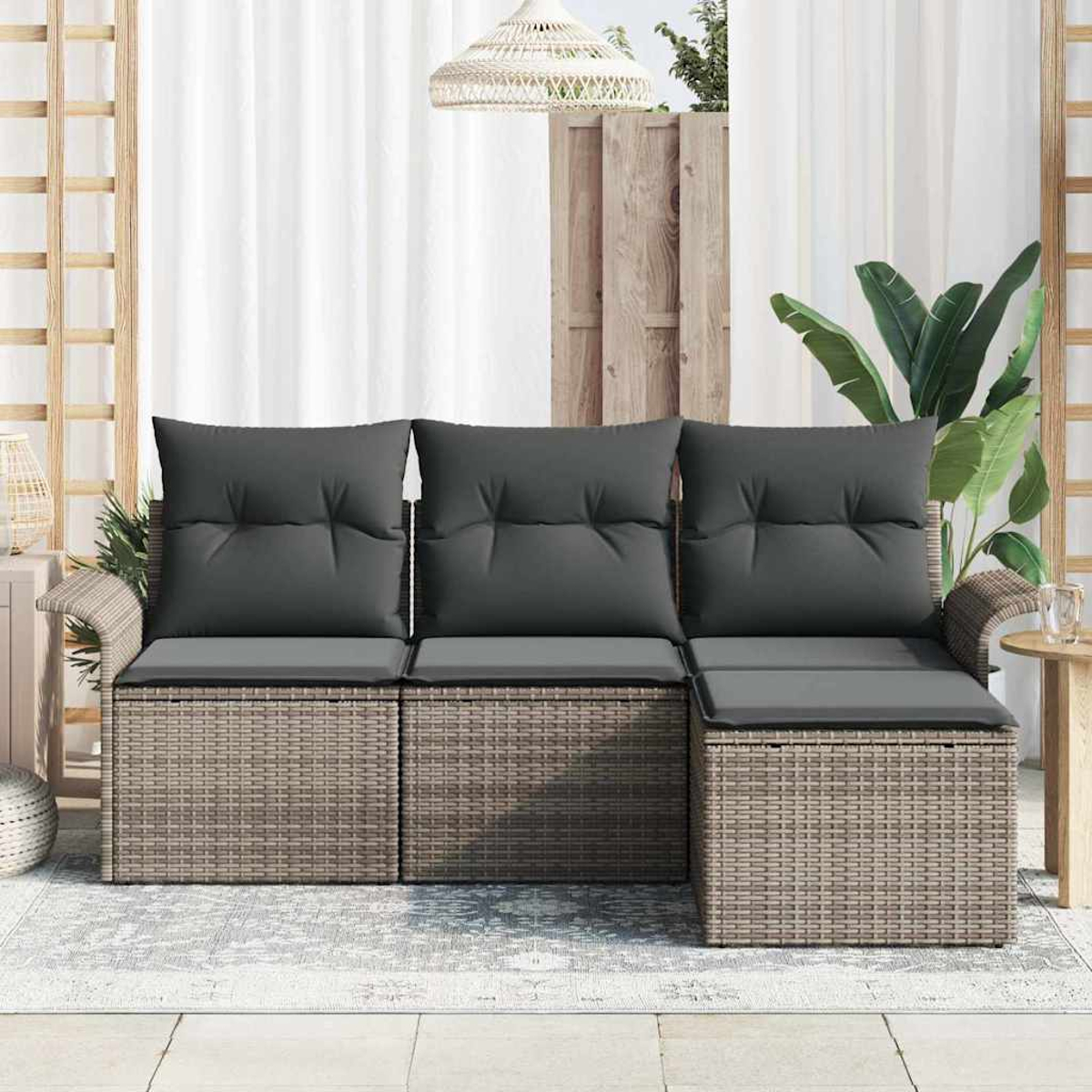 Outdoor-Ecksofa mit grauen Kissen. Geflochtene Basis, heller Hintergrund, weiße Vorhänge und Holzakzente. Dekorative Lampe und Pflanze.