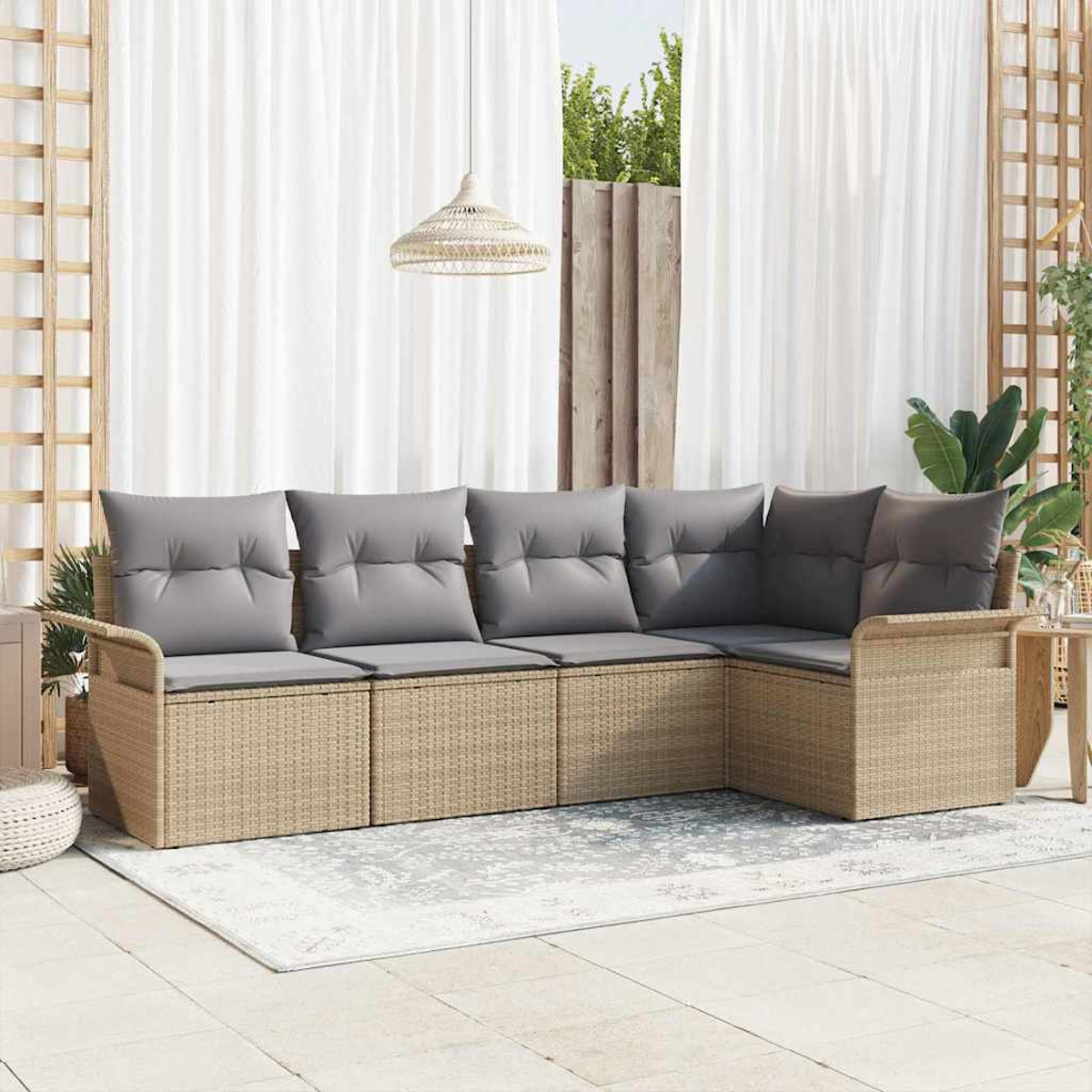 Outdoor-Ecksofa mit grauen Kissen auf einem gemusterten Teppich. Weiße Vorhänge und eine Hängelampe im Hintergrund.