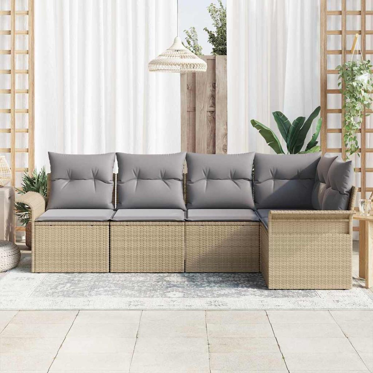 Ein Rattansofa mit grauen Kissen steht auf einer Terrasse. Weiße Vorhänge und Pflanzen umrahmen die Szene im Freien, mit einer Hängeleuchte.