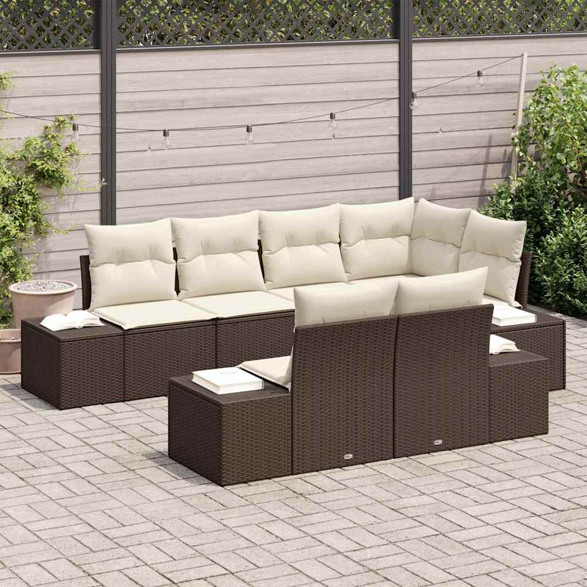 Gartenmöbel-Set aus Korbgeflecht. Braune gewebte Sitze und beige Kissen. Auf einer Ziegelterrasse vor einem Holzzaun.