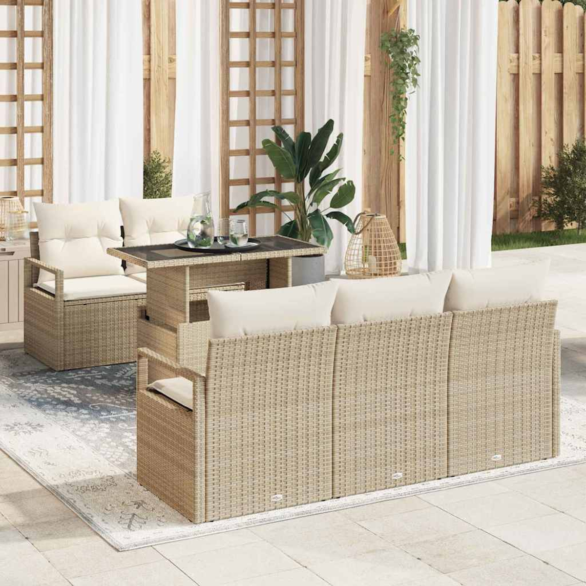 Gartenmöbel-Set mit Korbmöbeln, cremefarbenen Kissen und einem Tisch. Weiße Vorhänge und Pflanzen im Hintergrund.