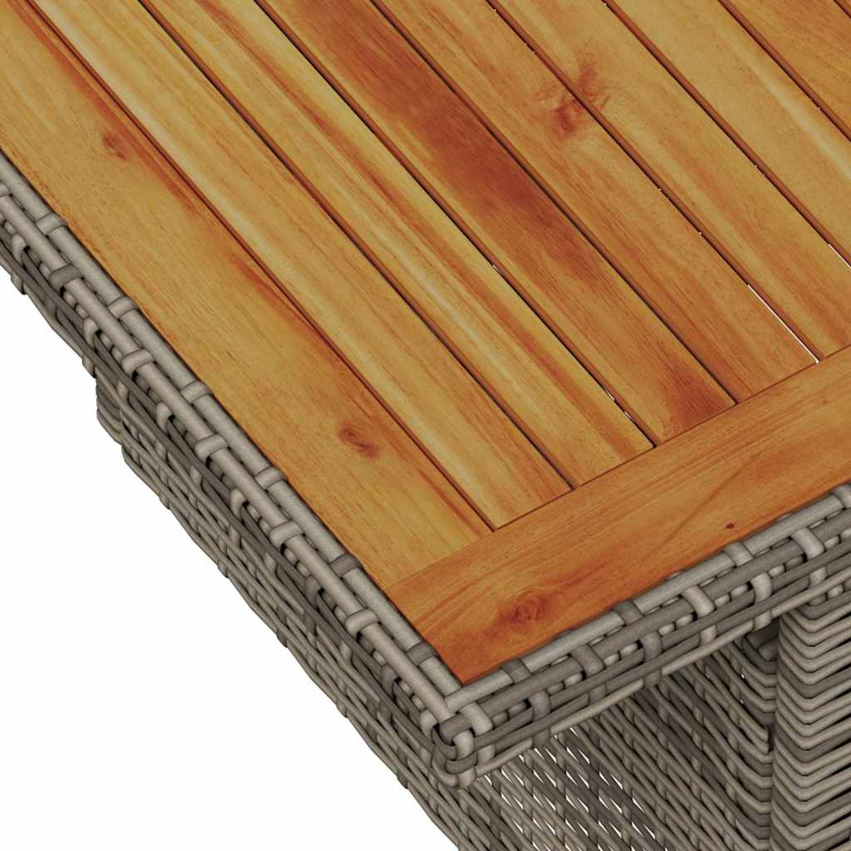 Nahaufnahme einer Tablecke. Sie hat eine Holzplatte mit hellbraunen Brettern. Der Rahmen besteht aus geflochtenem, grauem Material.