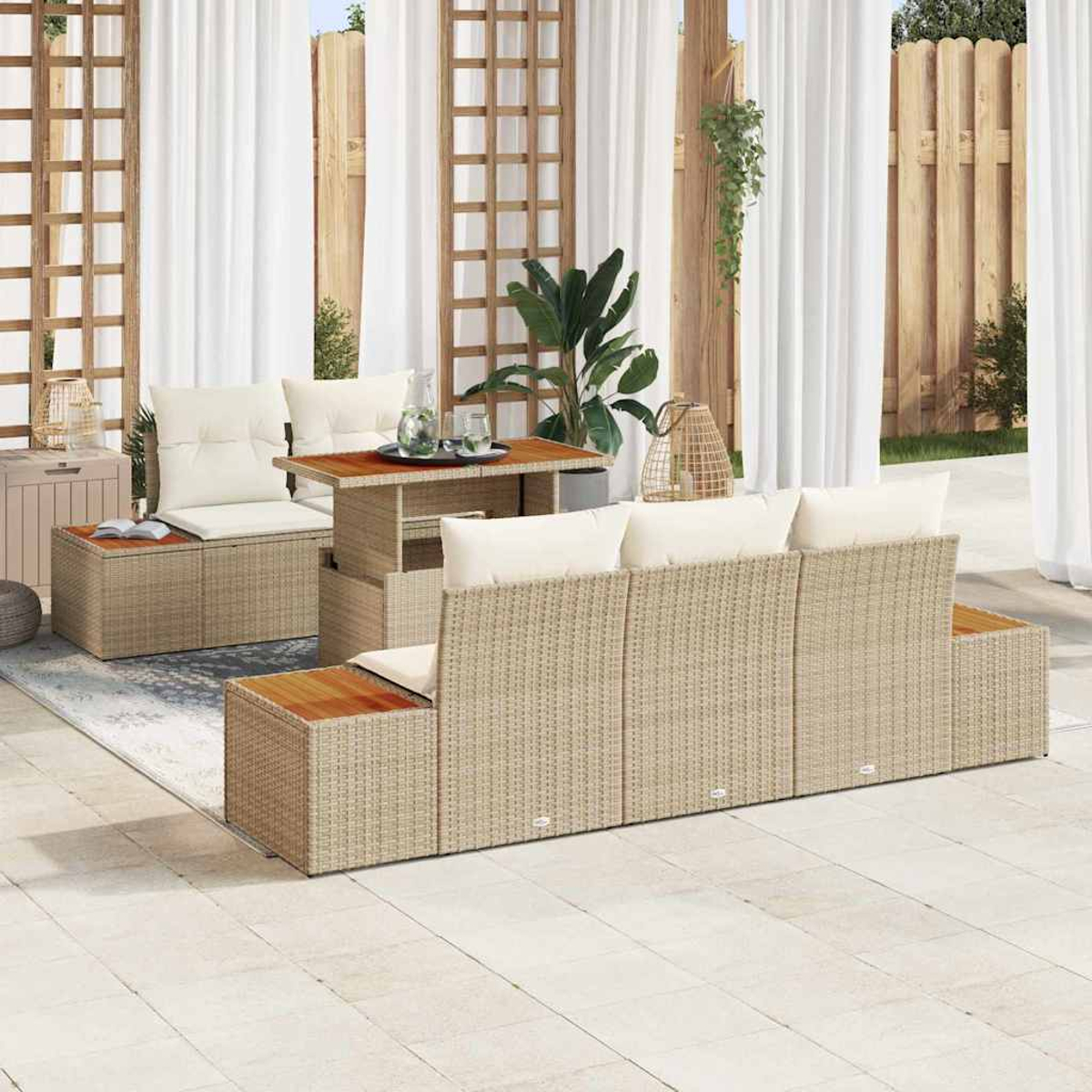 Gartenmöbel-Set aus Korbgeflecht mit Kissen, Tisch mit Glas und weißen Vorhängen im Hintergrund. Terrasse.
