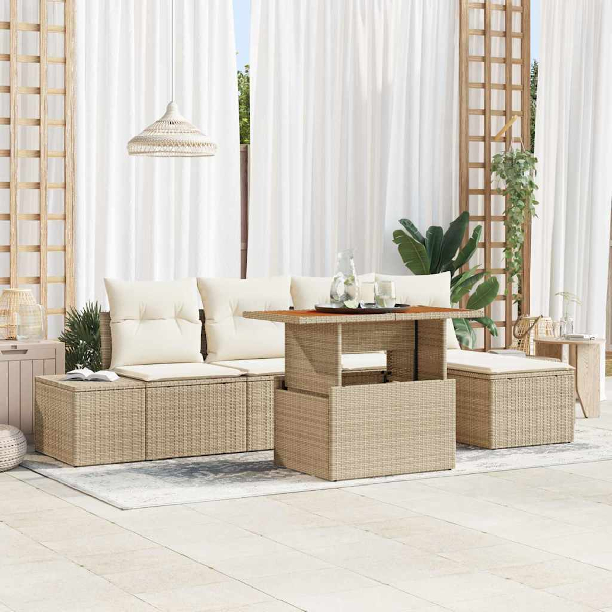 Außenbereich mit Rattan-Sofa, Tisch und Ottomane. Weiße Vorhänge im Hintergrund. Pflanzen und eine Pendelleuchte.