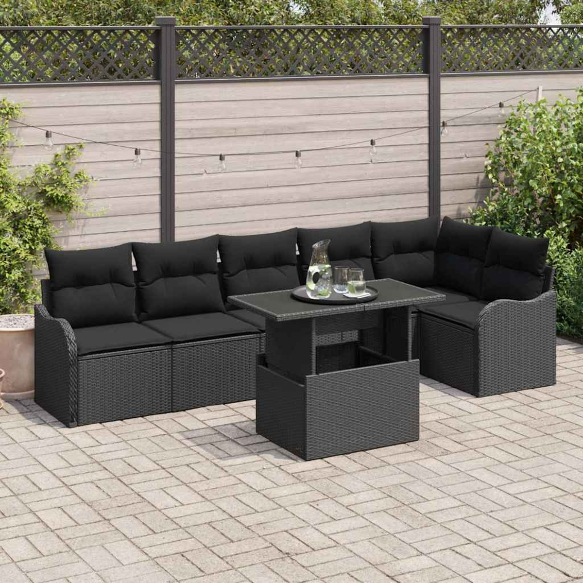 Gartenmöbel-Set mit schwarzen Kissen und einem Tisch mit Getränken. Im Hintergrund ein Zaun und Grün.