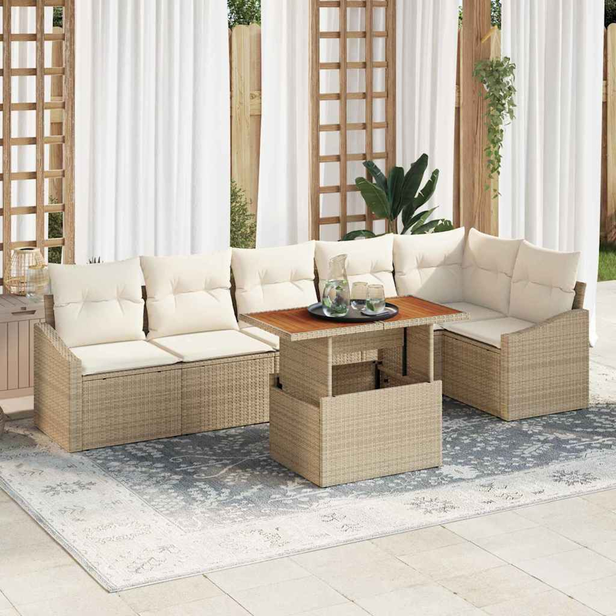 Outdoor-Sitzbereich mit beigefarbenen Kissen, einem Holztisch und einem gemusterten Teppich. Weiße Vorhänge und Grün im Hintergrund.