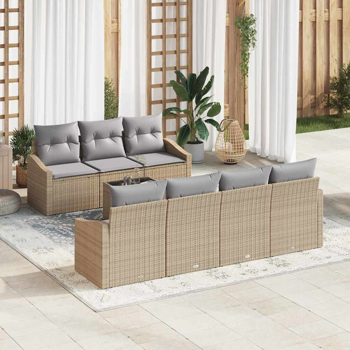 Garten-Set mit Korbsesseln, grauen Kissen, einem Teppich, Pflanzen und weißen Vorhängen. Szene ist auf einer Terrasse.
