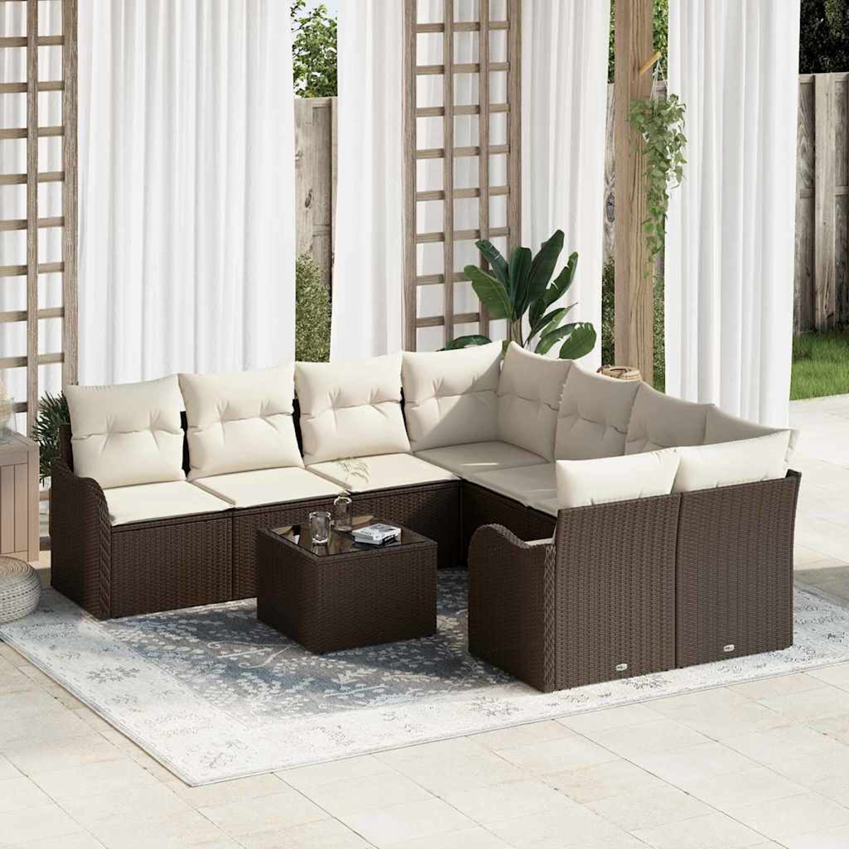 Outdoor-Ecksofa mit cremefarbenen Kissen und einem quadratischen Couchtisch auf einem gemusterten Teppich, vor weißen Vorhängen.