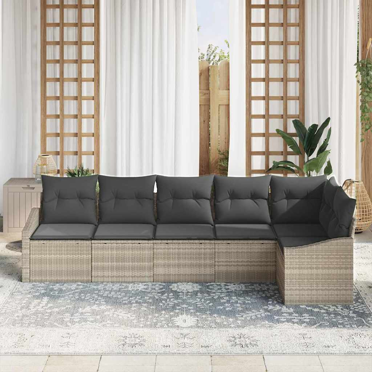 Outdoor-Ecksofa mit grauen Kissen auf einem gemusterten Teppich. Weiße Vorhänge und Holzgitter im Hintergrund.