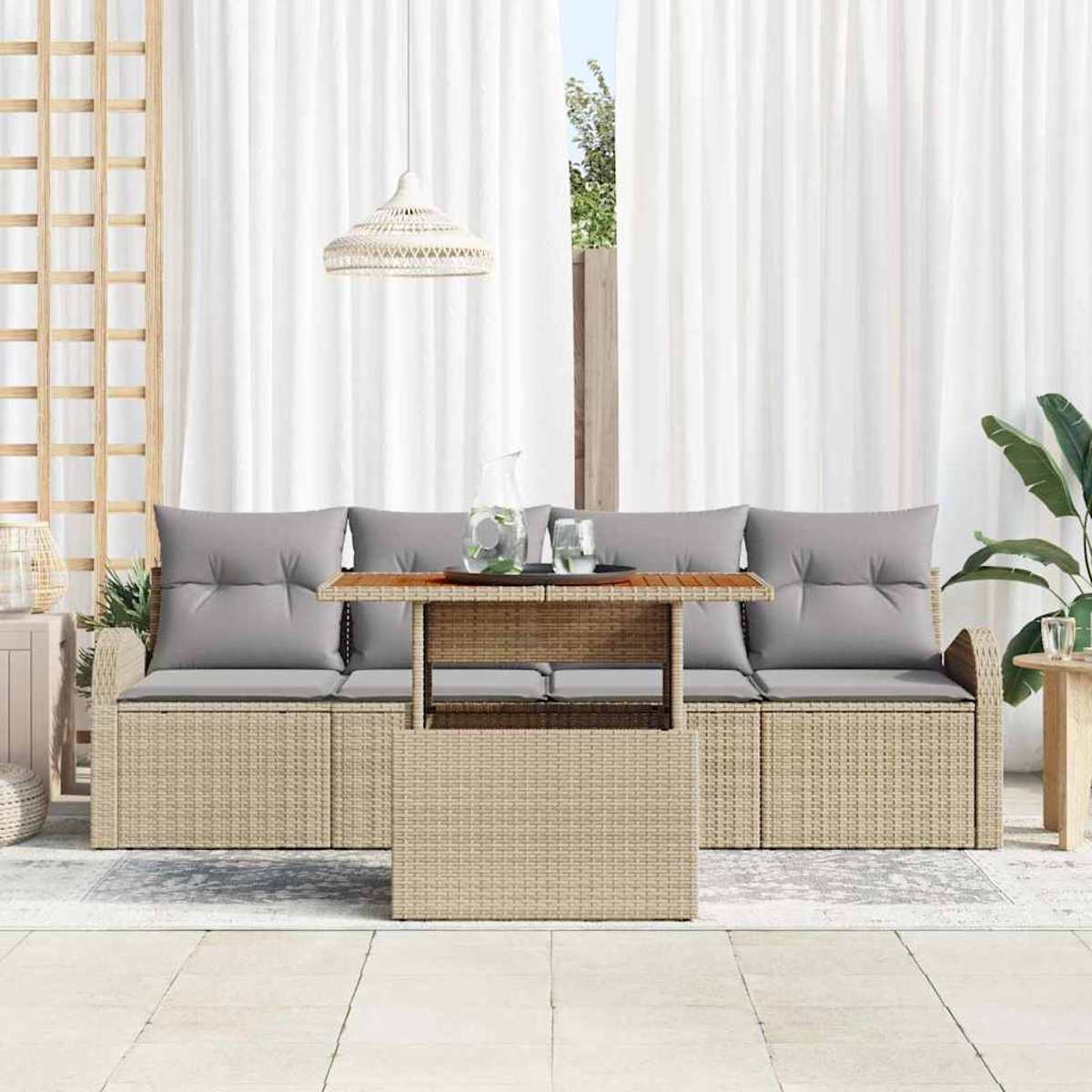 Outdoor-Set: beiges Korbmöbel mit grauen Kissen, Holztisch, weiße Vorhänge, Hängelampe und Pflanzen.