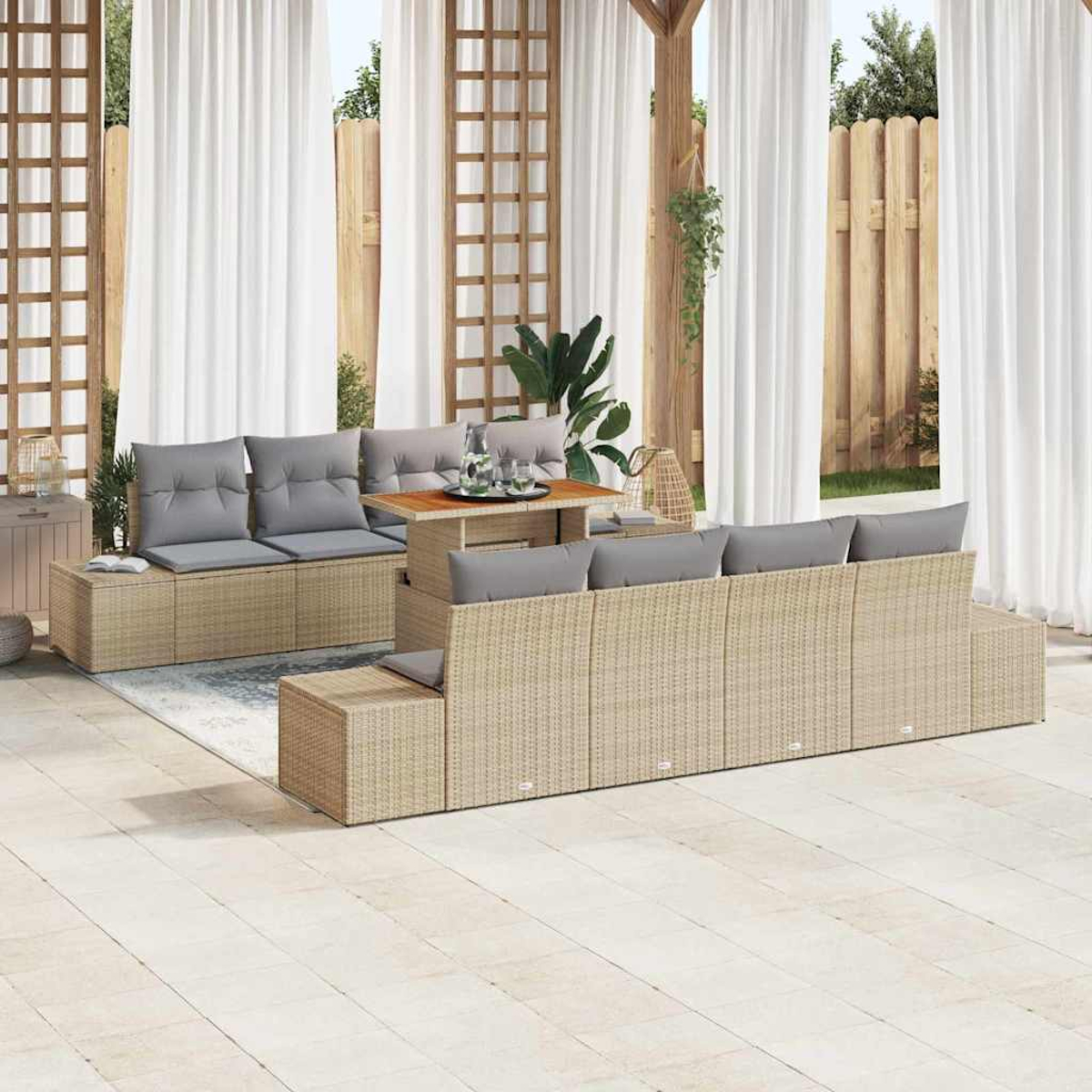 Juego de muebles de mimbre para exterior con cojines grises, mesa y cortinas. Fondo con valla de madera, celosía y plantas.