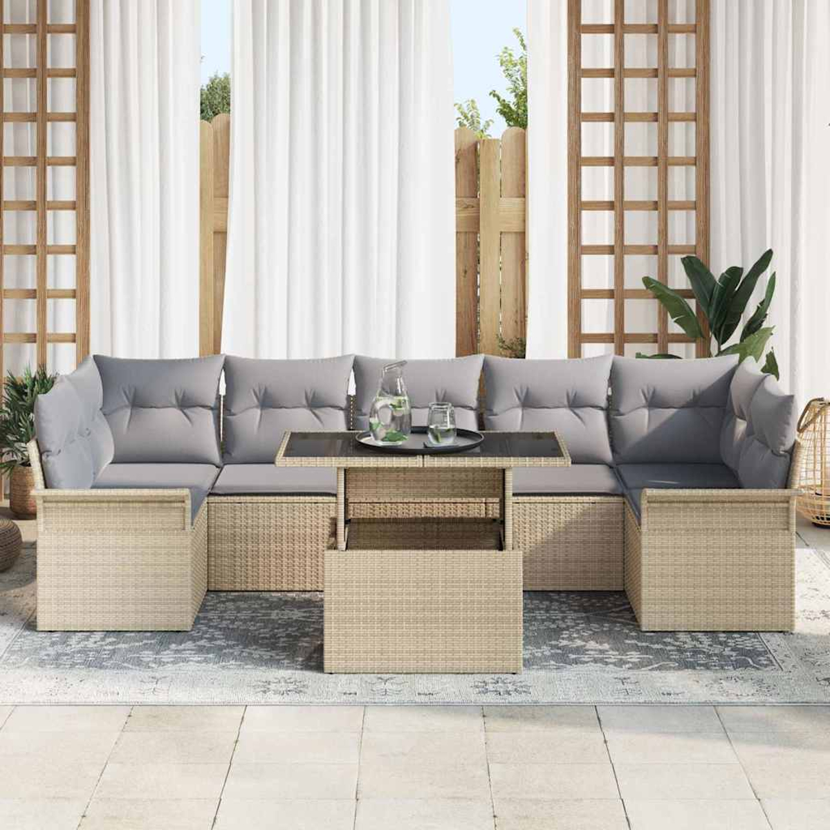 Outdoor-Wicker-Ecksofa mit grauen Kissen, einem Tisch mit Glasplatte und weißen Vorhängen im Hintergrund. Eine entspannte Terrasseneinstellung.