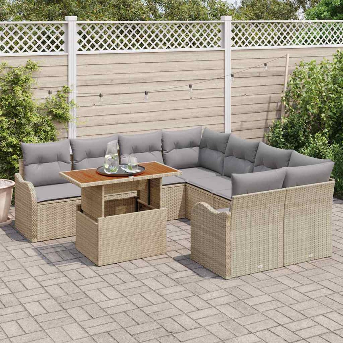 Outdoor-Wicker-Sofa mit grauen Kissen und einem Hebetisch. Ein Tablett mit Getränken steht darauf. Aufgestellt in einem Garten mit Zaun.