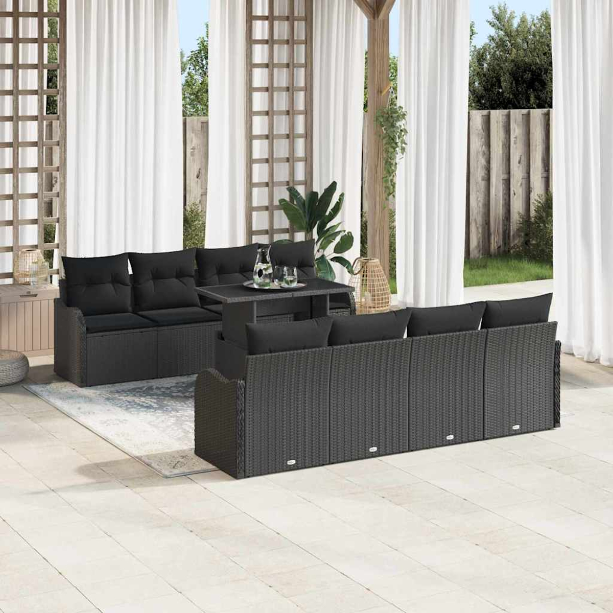 Garten-Terrassenset mit schwarzen Korbmöbeln: Sofa, Tisch und Stühle. Weiße Vorhänge und Holzgitter im Hintergrund.