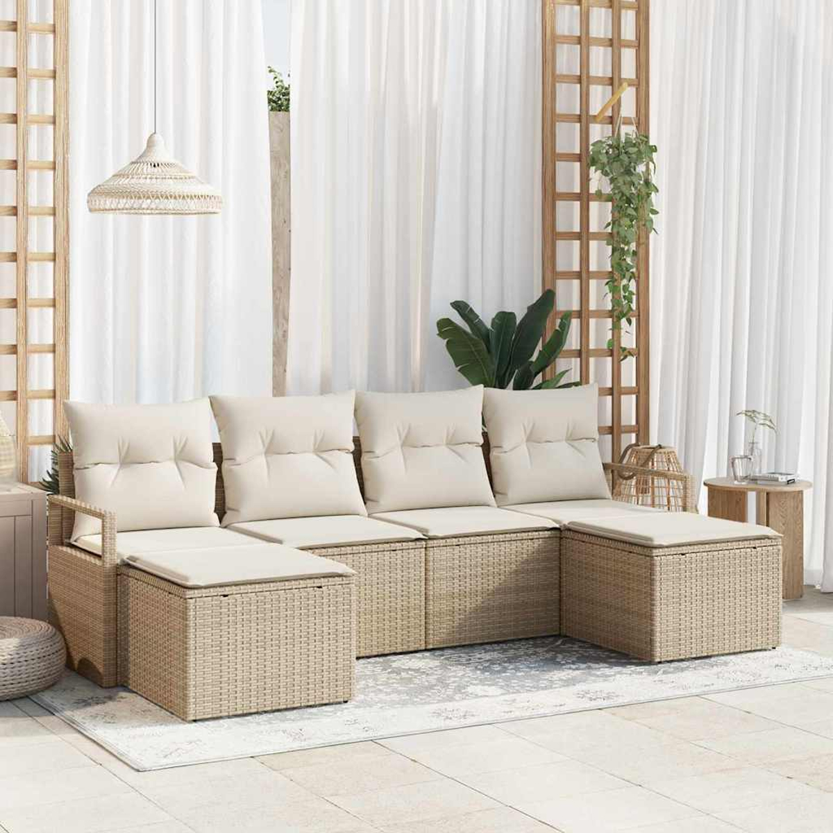 Outdoor-Sitzgelegenheit mit beigen Kissen. Geflochtene Korbmöbel auf einer Terrasse, mit weißen Vorhängen und hängenden Pflanzen im Hintergrund.