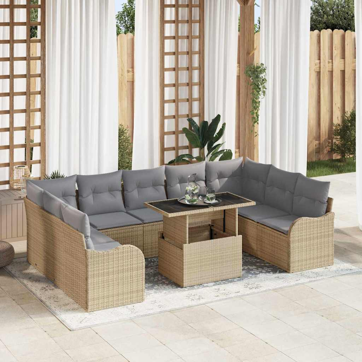 Outdoor-Sitzgruppe mit Korbs Sofas, grauen Kissen und einem Tisch mit Hubfunktion. Vorhänge und Holzzaun im Hintergrund.