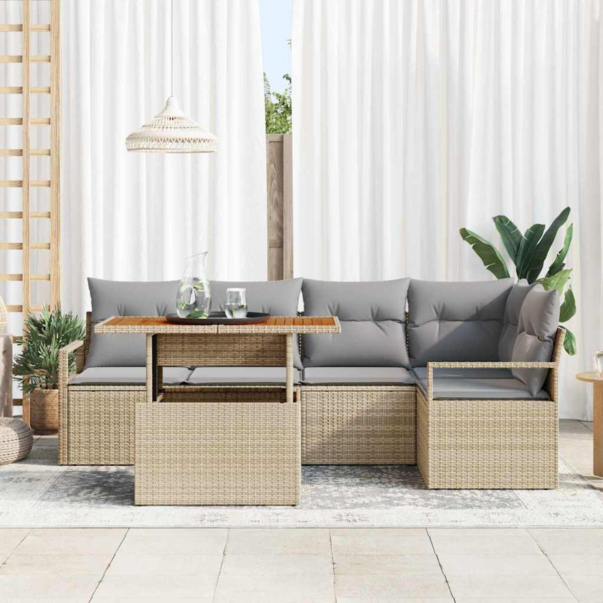 Gartenmöbel-Set mit Tisch, Ecksofa mit grauen Kissen und weißen Vorhängen im Hintergrund.