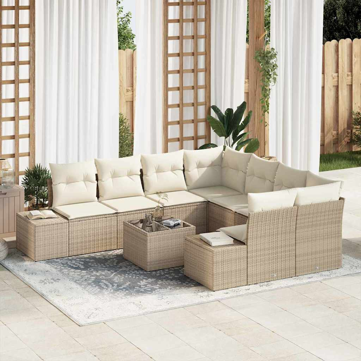 Beiges Rattan-Ecksofa für den Außenbereich mit cremefarbenen Kissen, zwei kleinen Tischen und einem Teppich. Hintergrund mit Vorhängen, Holzrahmen und einem Zaun.