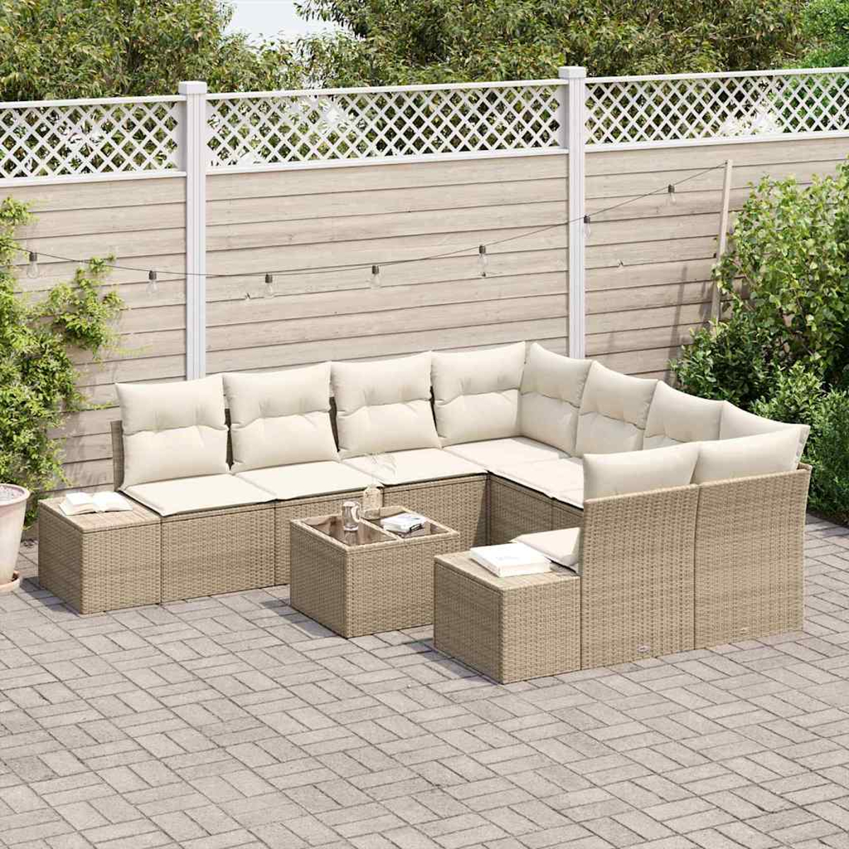 Outdoor-Ecksofa mit beigen Kissen auf einer Steinterrasse. Davor steht ein Couchtisch. Im Hintergrund sind ein Zaun und Grün zu sehen.