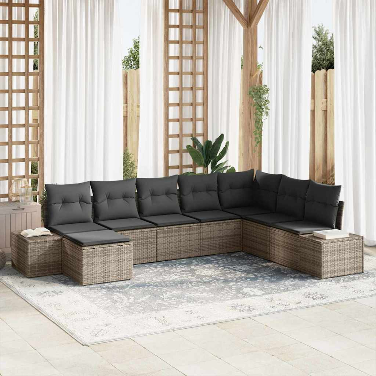 Ein großes Outdoor-Ecksofa mit grauen Kissen steht auf einem Teppich. Weiße Vorhänge und Holzstrukturen sind im Hintergrund.