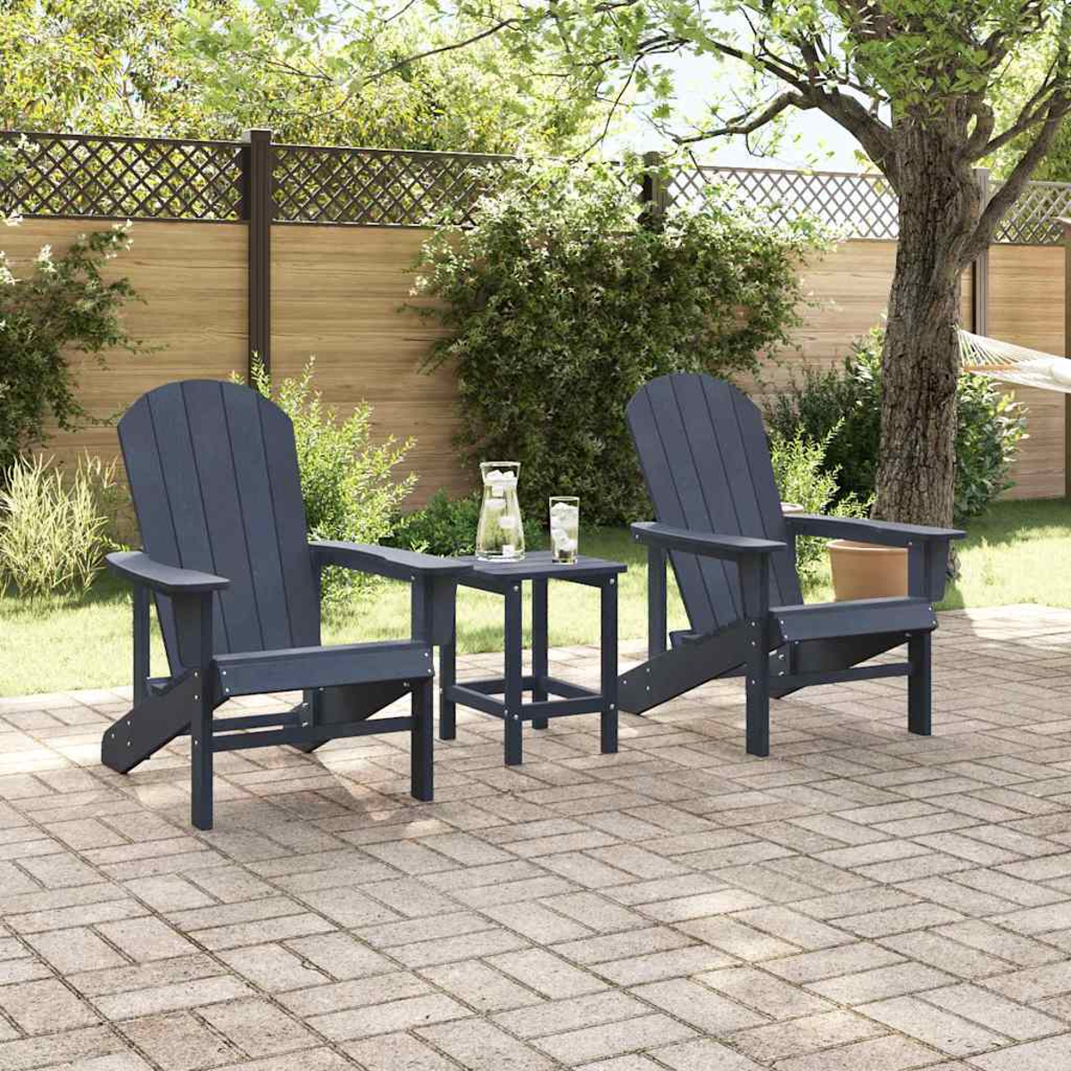 Dos sillas Adirondack azules y una mesita sobre un patio de ladrillos. Una jarra y vasos sobre la mesa, con una valla de madera al fondo.