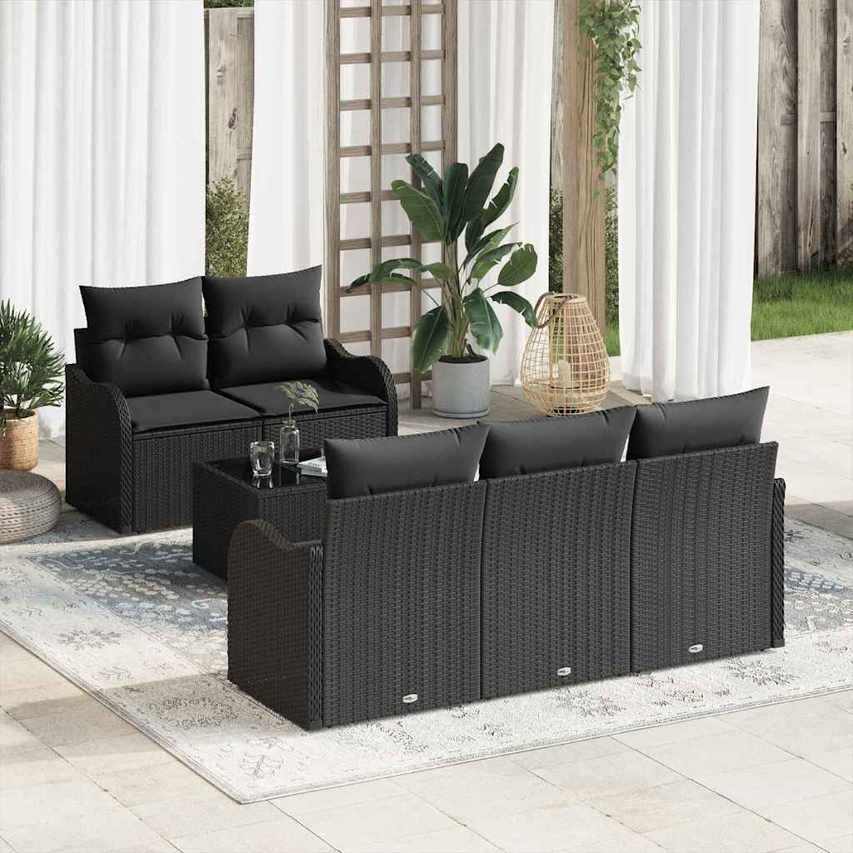 Garten-Sitzgruppe mit schwarzen Kissen auf einem gemusterten Teppich. Enthält ein Zweisitzer, Sofa und Couchtisch, mit Pflanzen und Vorhängen.
