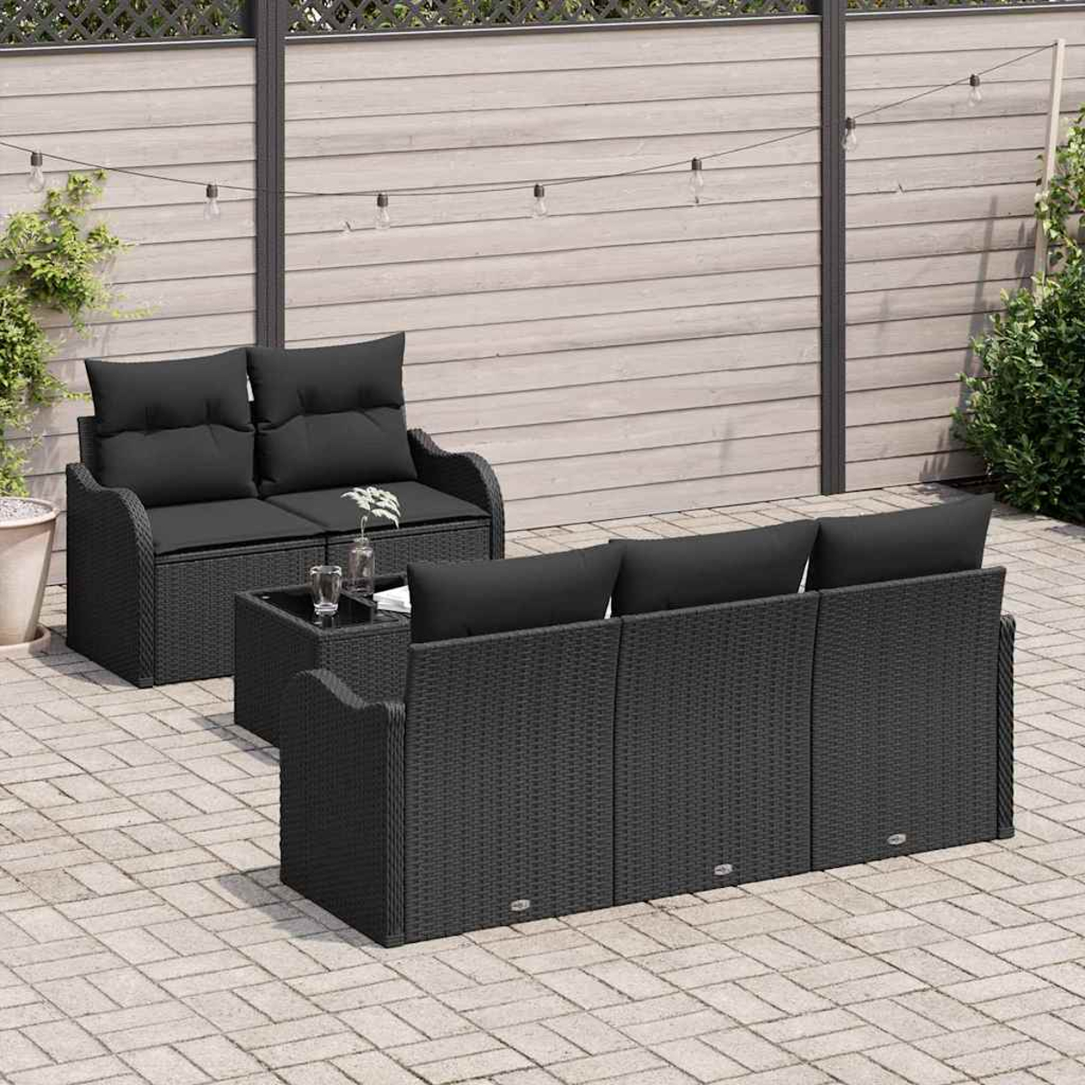 Gartenmöbel. Schwarzes Korbmöbel-Set mit Kissen und Tisch. Auf einer Backstein-Terrasse. Lichterketten hängen darüber.