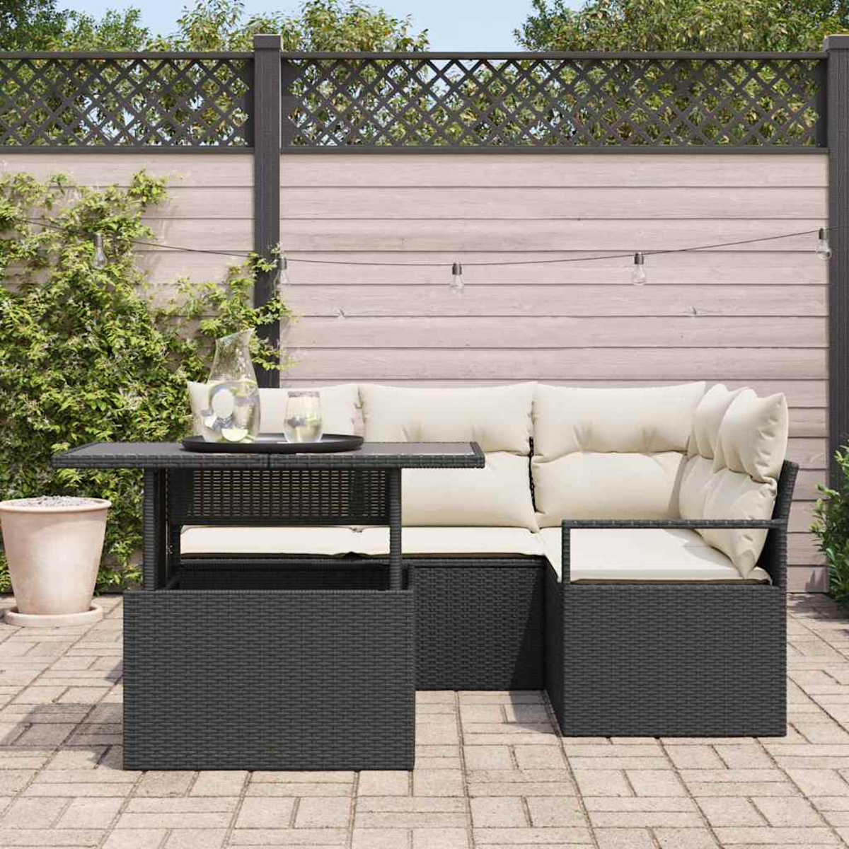 Garten-Sitzgruppe mit Tisch. Schwarze Korbmöbel mit cremefarbenen Kissen. Tisch hat Getränke. Zaun und Grün im Hintergrund.