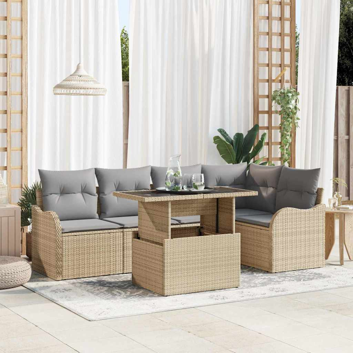 Eine Außenterrasse mit Rattanmöbeln, grauen Kissen, einem Tisch mit Getränken und weißen Vorhängen im Hintergrund.