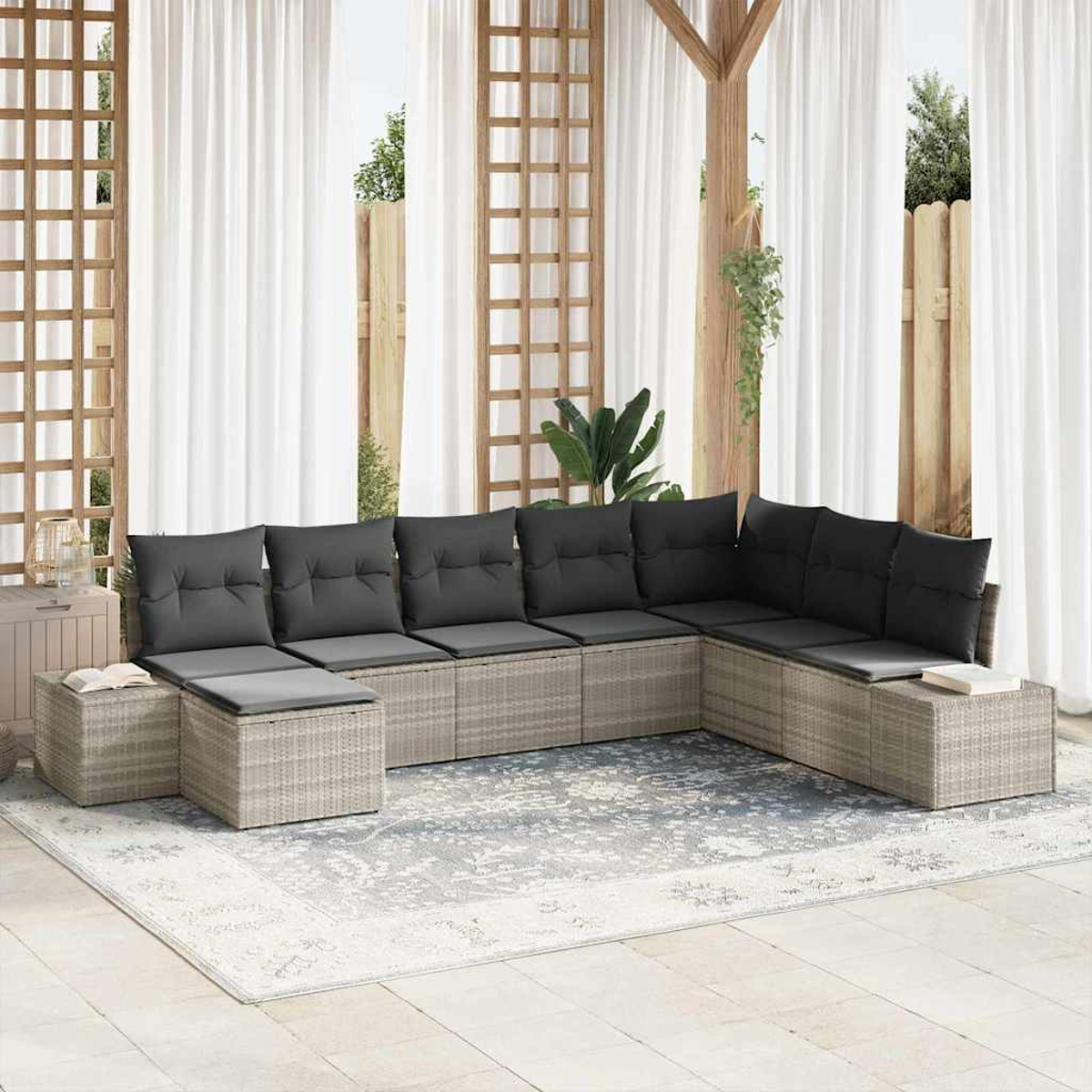 Sof á seccional exterior con cojines grises sobre una alfombra, en un patio con cortinas y detalles de madera.