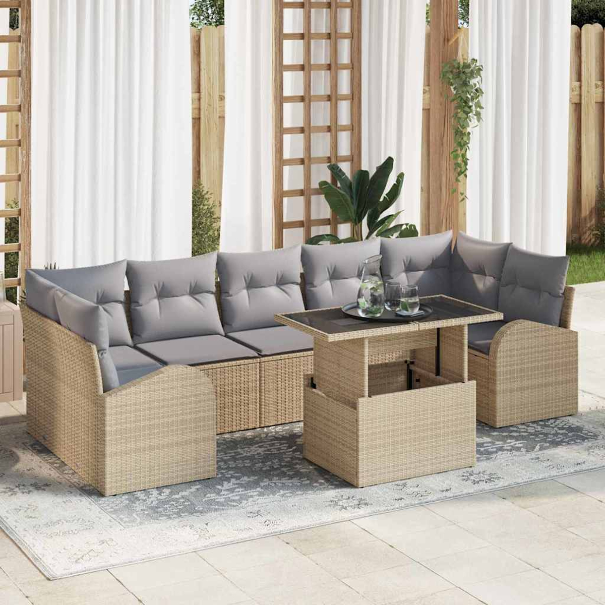 Gartenmöbel-Set aus Korbgeflecht mit grauen Kissen, einem Tisch mit Hubfunktion und einem Teppich. Weiße Vorhänge und Holzgitter im Hintergrund.