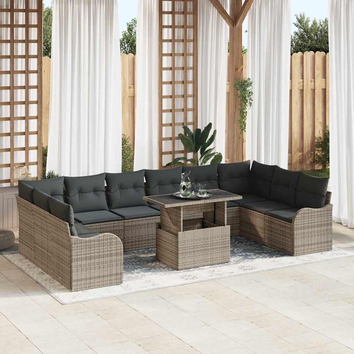 Gartenmöbel-Set mit grauen Kissen, einem Tisch mit Getränken und weißen Vorhängen im Hintergrund.