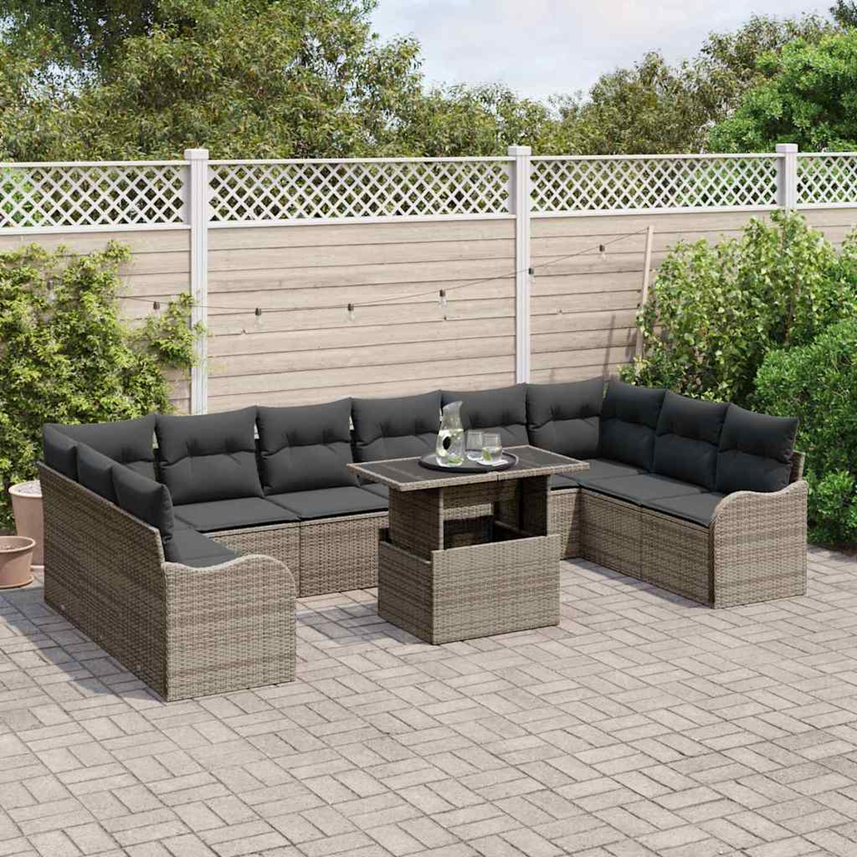 Garten-Sitzgruppe mit grauen Kissen und einem Tisch auf einer gepflasterten Terrasse. Ein weißer Zaun und Grünzeug sind im Hintergrund.
