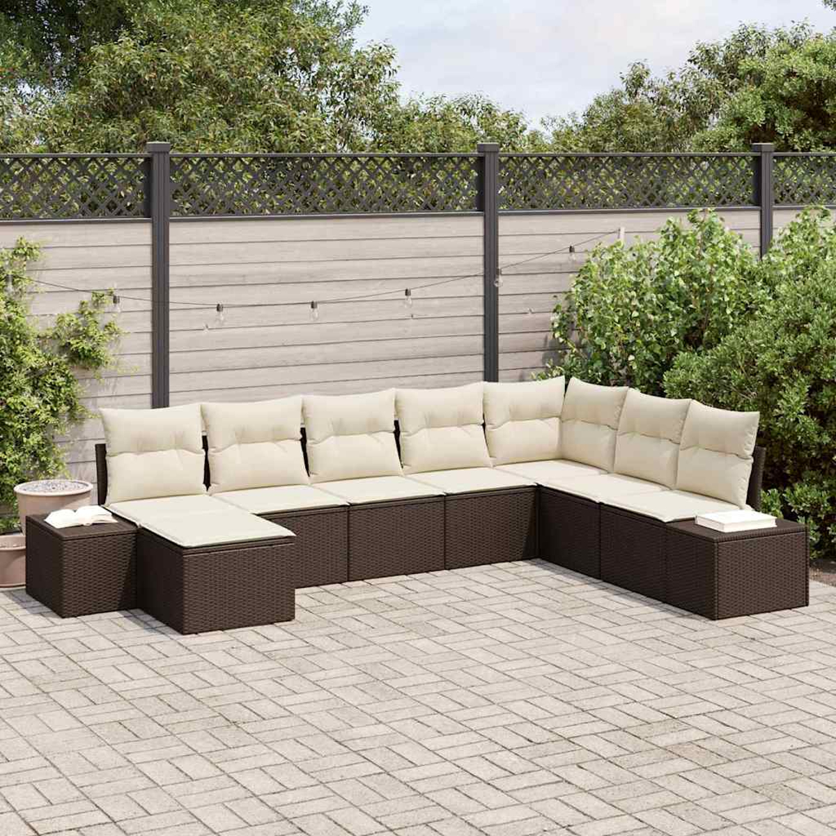 Ein Ecksofa im Freien mit cremefarbenen Kissen auf einer braunen Korbbasis steht auf einer Backsteinterrasse. Im Hintergrund sind ein Zaun und Grün.