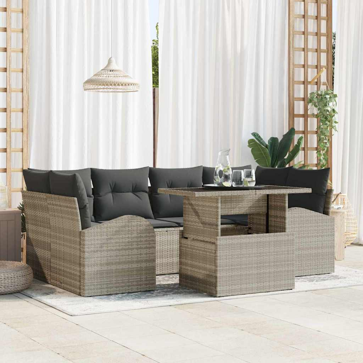 Terrassenmöbel mit grauen Kissen, einem Tisch und weißen Vorhängen im Hintergrund. Eine Pendelleuchte hängt oben.
