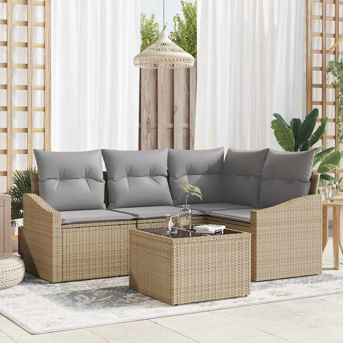 Ein beiges Outdoor-Ecksofa aus Korbgeflecht mit grauen Kissen und einem passenden Couchtisch. Weiße Vorhänge und eine Hängeleuchte im Hintergrund.