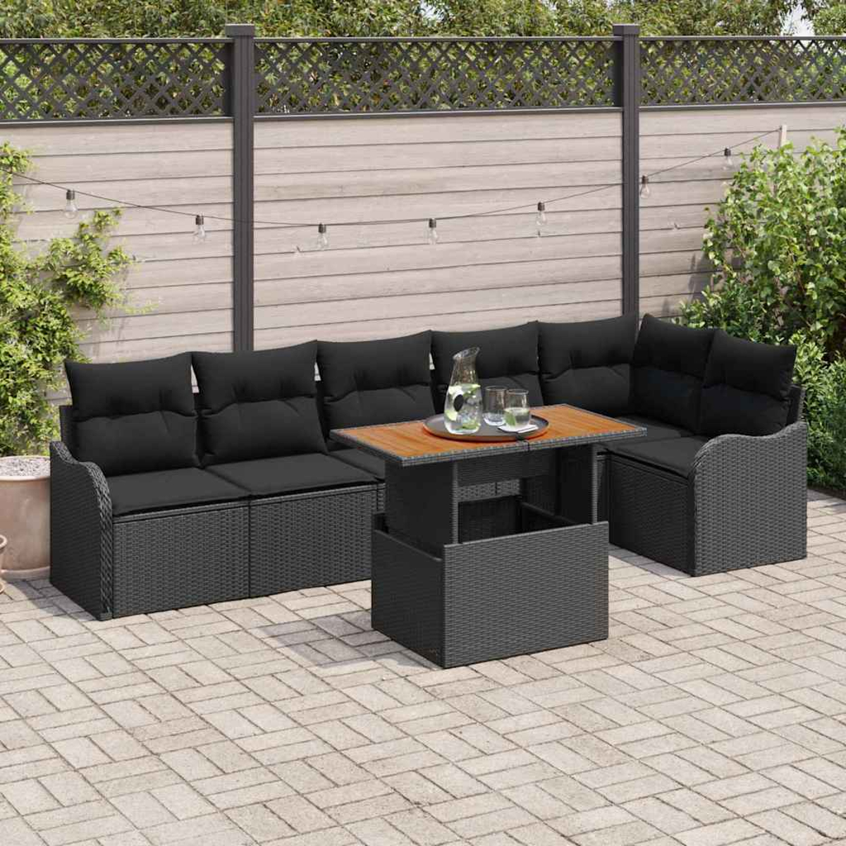 Outdoor-Sofa aus schwarzem Korbgeflecht mit schwarzen Kissen, einem Holztisch und einer Wasserkaraffe auf einer Terrasse.
