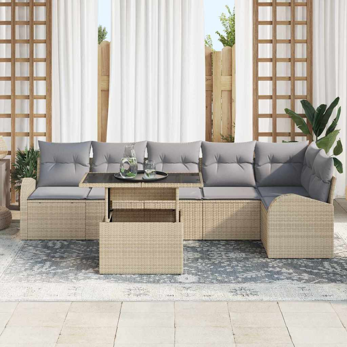 Sofá seccional exterior con cojines grises, mesa con bebidas, alfombra, cortinas y una valla de madera al fondo.