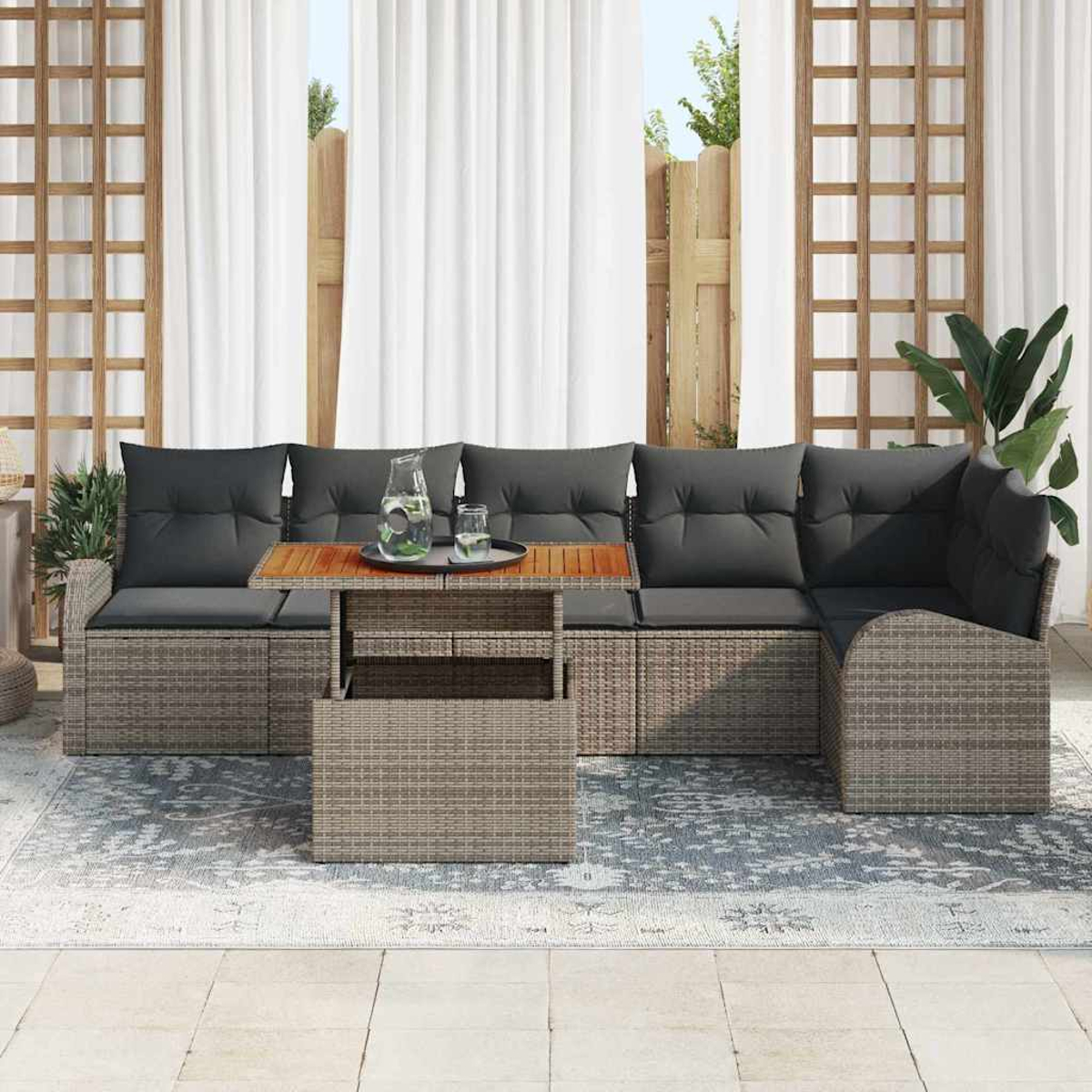 Outdoor-Ecksofa mit grauen Kissen, Holztisch mit Getränken. Weiße Vorhänge und Holzzaun im Hintergrund.