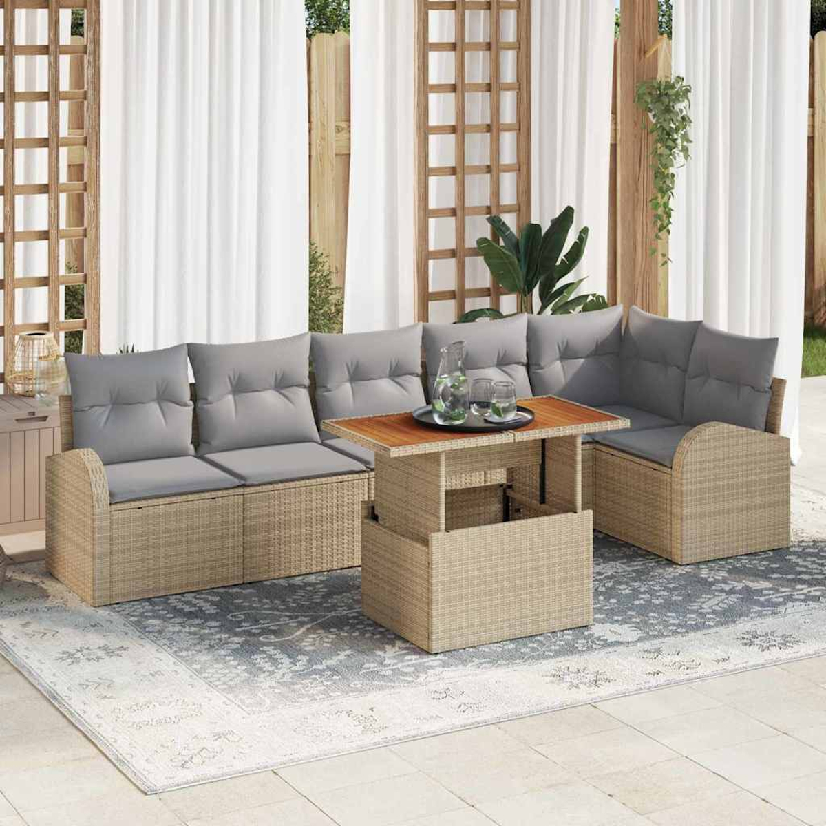 Outdoor-Sitzbereich mit Korbmöbeln, grauen Kissen, einem Couchtisch und transparenten weißen Vorhängen im Hintergrund.