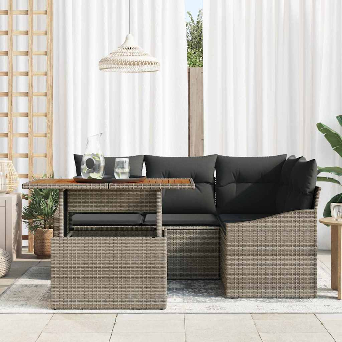 Außenszene mit einem Rattansofa, Tisch und weißen Vorhängen. Auf dem Tisch stehen eine Wasserkaraffe und Gläser. Eine Hängelampe ist oben.