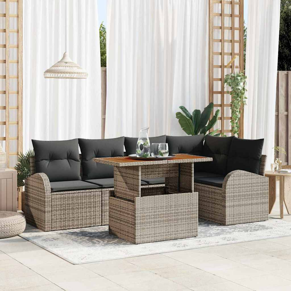Terrassenset mit gewebten Möbeln, grauen Kissen und einem Holztisch. Weiße Vorhänge und Pflanzen im Hintergrund.