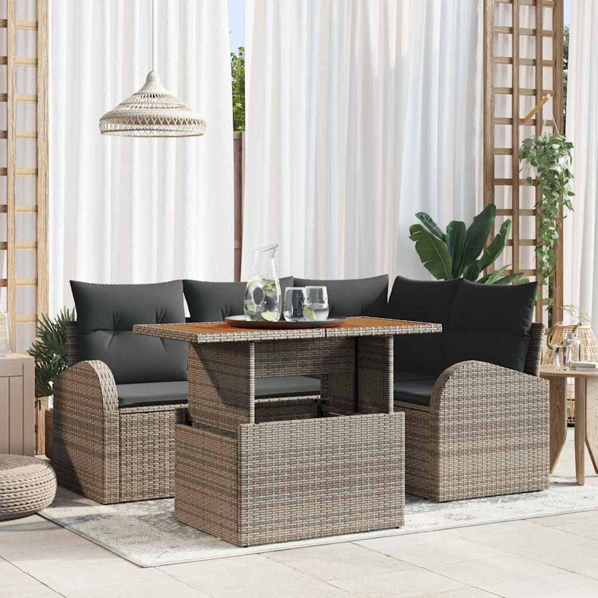 Garten-Terrassenset mit einem Tisch mit Hubplatte, zwei Sofas mit schwarzen Kissen und einer gewebten Lampe. Weiße Vorhänge im Hintergrund.