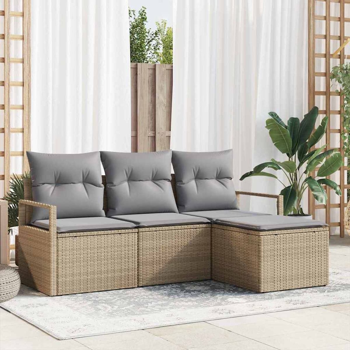 Geflochtenes Outdoor-Ecksofa mit grauen Kissen. Weiße Vorhänge und Grün im Hintergrund. Auf dem Boden liegt ein Teppich.