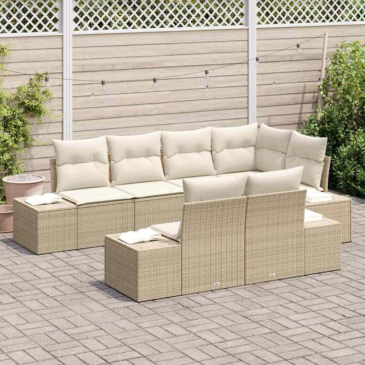 Outdoor-Rattan-Sofagarnitur mit cremefarbenen Kissen. Auf einer Ziegelterrasse mit Holzzaun und Lichterketten im Hintergrund.