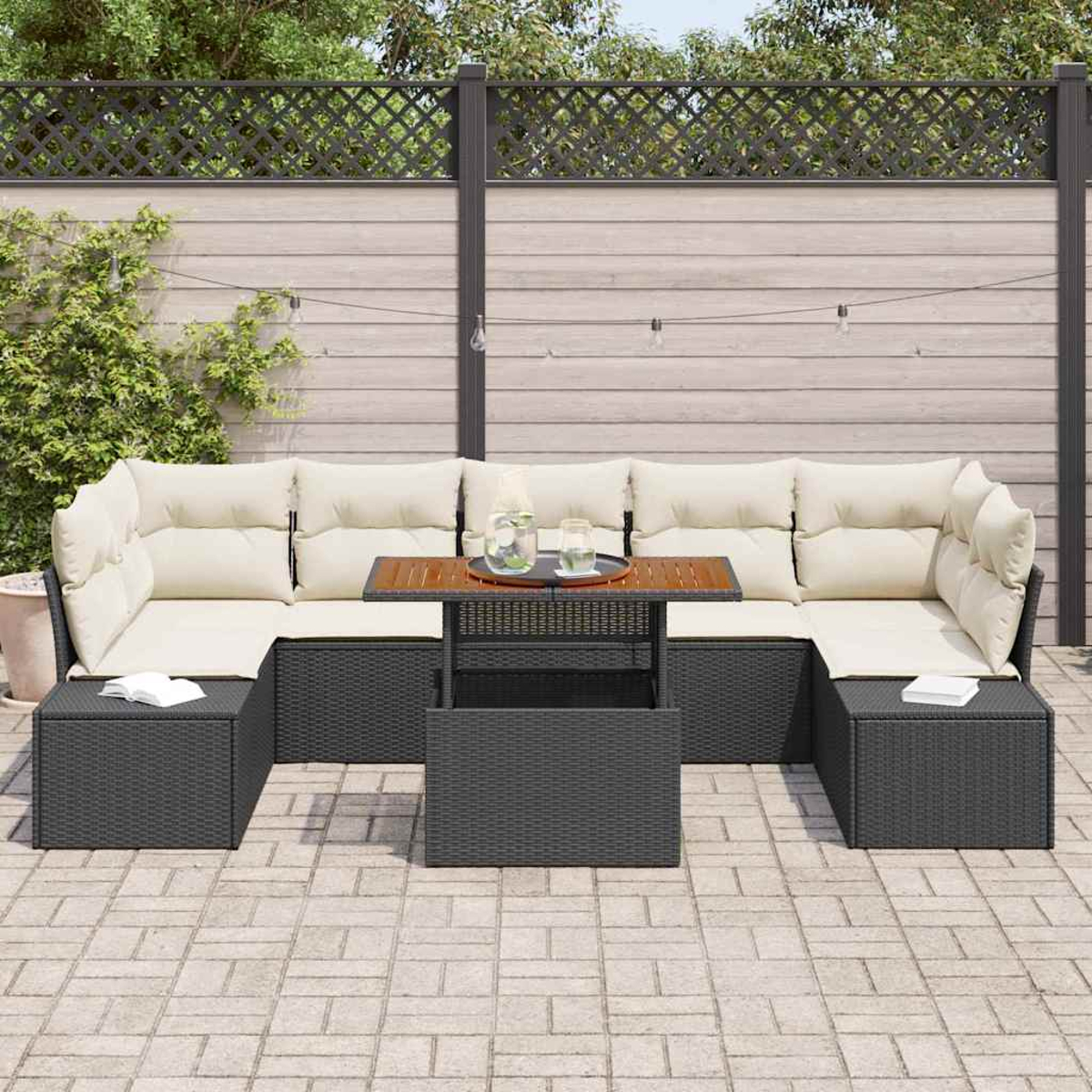 Outdoor-Ecksofa mit cremefarbenen Kissen, dunklem Tisch und passenden Ottomanen. Holzzaun und Grün in Hintergrund. Gepflasterte Terrasse.