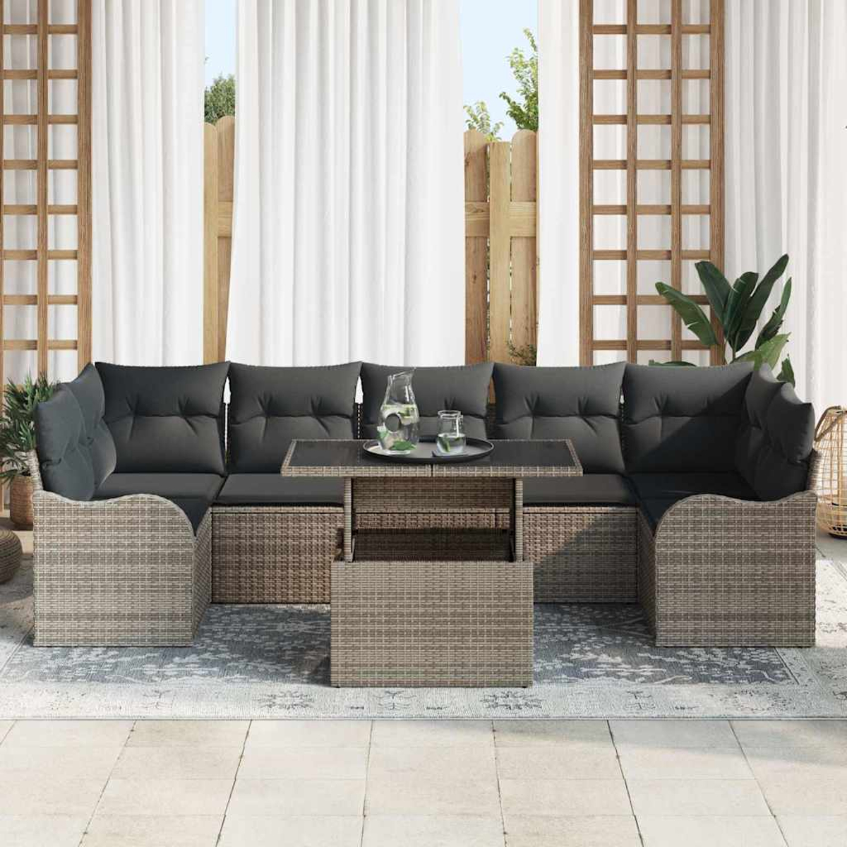 Outdoor-Ecksofa mit grauen Kissen und einem Tisch. Weiße Vorhänge und ein Holzzaun sind im Hintergrund.