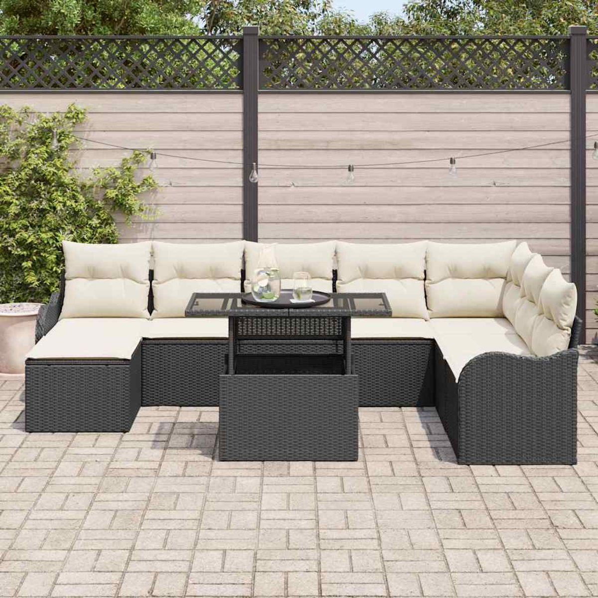 Outdoor-Ecksofa mit cremefarbenen Kissen und einem kleinen Tisch. Ein grauer Zaun und eine Ziegelterrasse sind im Hintergrund.
